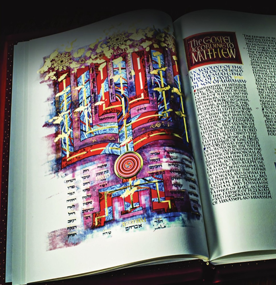 The Saint John's Bible open to the Gospel according to Matthew, with gold illumination and calligraphy.
