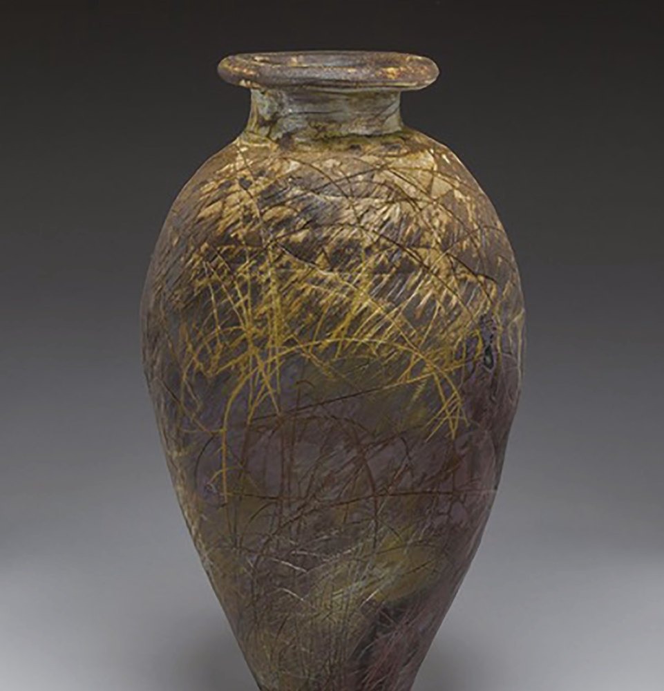 A wood-fired vessel by Richard Bresnahan, its surface marked by ash and incised grass-like lines.